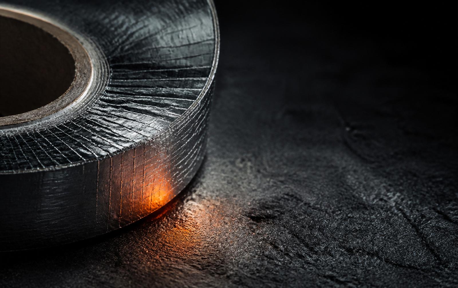Industrial aluminum foil tape roll under warm ember light
